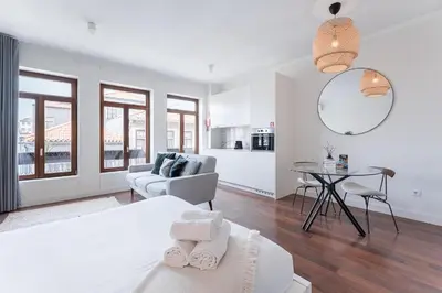 a white room with a bed and a table at Studio-Fast Wi-Fi- AC -5 min Trindade Metro&Clérigos in Porto