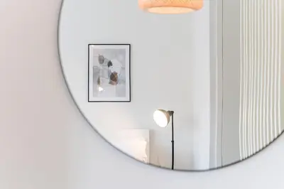 a mirror in a white room with a lamp at Studio-Fast Wi-Fi- AC -5 min Trindade Metro&Clérigos in Porto