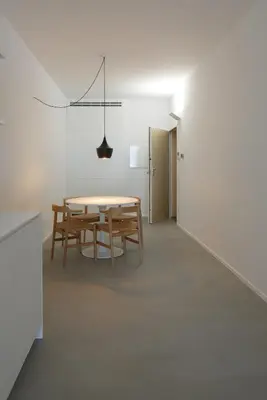 a kitchen with white counters and a dining room with a table at Urban Residences Sacadura in Porto