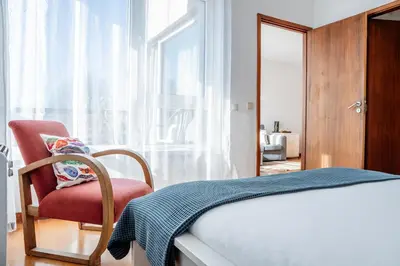 a bedroom with a bed and a chair and a window at Skyline Invicta in Porto