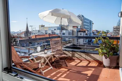 a table and chairs on a balcony with an umbrella at Skyline Invicta in Porto