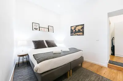 a white bedroom with a bed and a table at Cantinho do Porto - Metro 1 Minute Away in Porto