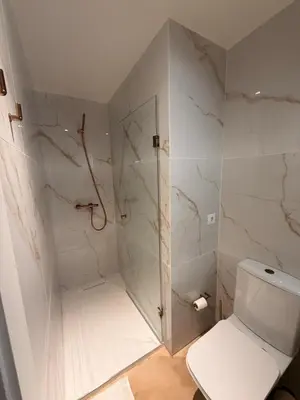 a white bathroom with a shower and a toilet at Guindais River View II in Porto