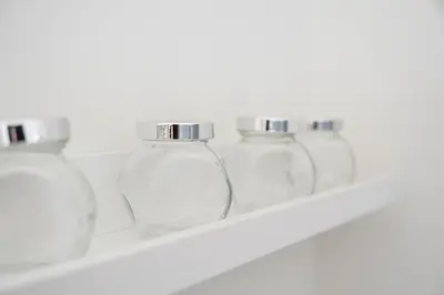 a row of glass jars on a shelf at Sunny one bedroom apartment in Porto