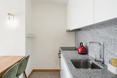 a kitchen with a sink and a red kettle on the counter at Sunny one bedroom apartment in Porto
