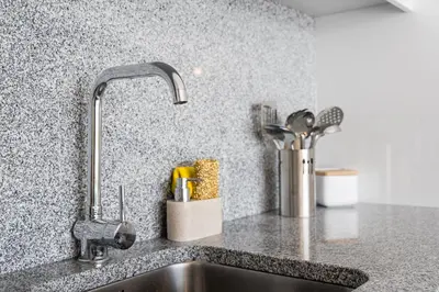 a kitchen sink with a faucet and some utensils at Sunny one bedroom apartment in Porto