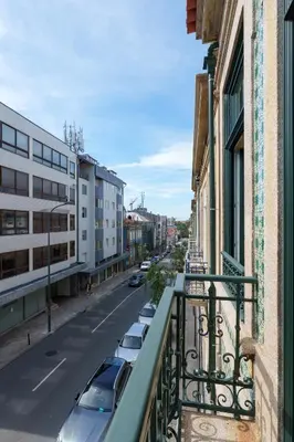 a balcony of a building with cars parked on the street at VIVA Quinta Modernista Flat in Porto