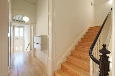 a staircase in a home with wooden floors and a window at VIVA Quinta Modernista Flat in Porto