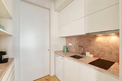 a kitchen with white cabinets and a sink at VIVA Cedofeita Serviced Apartments in Porto