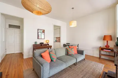 a living room with a gray couch with colorful pillows at VIVA Cedofeita Serviced Apartments in Porto