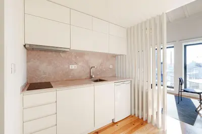 a kitchen with white cabinets and a sink at VIVA Cedofeita Serviced Apartments in Porto