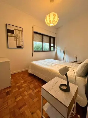 a bedroom with a bed and a table with a lamp at Good end Oporto View in Porto