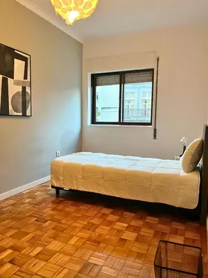 a bedroom with a bed in a room with a window at Good end Oporto View in Porto