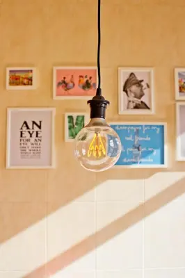 a light bulb hanging from a wall with pictures at Porto Pacific - Rua das Flores - Flower Street in Porto