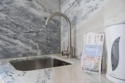 a kitchen counter with a sink and a book at GuestReady - Urban retreat in Boavista in Porto