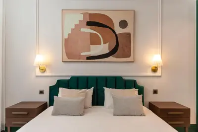 a bedroom with a large bed with a green headboard at Cosy Flat in Porto with Private Patio & Garden Area by Lisbeyond in Porto