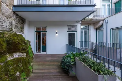 a wooden walkway leading to a house with a balcony at Cosy Flat in Porto with Private Patio & Garden Area by Lisbeyond in Porto