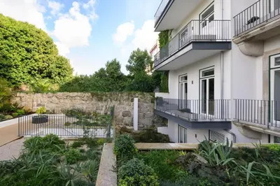 a house with a stone wall and a courtyard at Cosy Flat in Porto with Private Patio & Garden Area by Lisbeyond in Porto