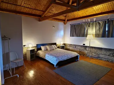 a bedroom with a bed and a large window at Estúdio na Estação in Porto