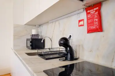 a kitchen counter with a sink and a microwave at 1-Bedroom Apartment with Terrace next to Bonfim Metro Station in Porto