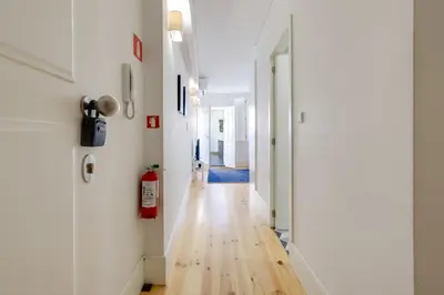 a hallway with white walls and a hard wood floor at 1-Bedroom Apartment with Terrace next to Bonfim Metro Station in Porto