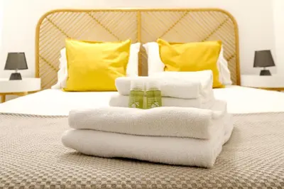 a pile of towels sitting on top of a bed at 1-Bedroom Apartment with Terrace next to Bonfim Metro Station in Porto
