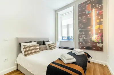 a living room with a couch and a kitchen at Heroísmo, stylish 2 bedroom apartment in Porto