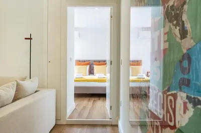 a bedroom with a large white bed with striped pillows at Heroísmo, stylish 2 bedroom apartment in Porto
