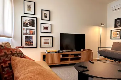 a living room with a couch and a flat screen tv at BOLHÃO - Stylish downtown two bedroom apartment in Porto