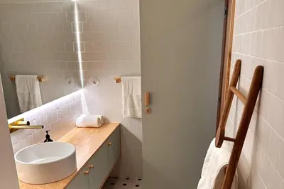 a bathroom with a white sink and a mirror at BOLHÃO - Stylish downtown two bedroom apartment in Porto