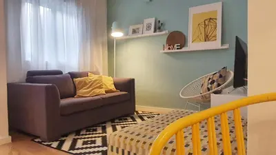 a living room with a couch and a crib at T2P Pilar House in Vila Nova de Gaia