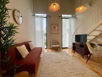 a living room with a couch and a television at Terrace Loft near Porto Center in Porto