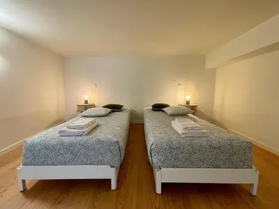 two beds in a room with two lights on the wall at Terrace Loft near Porto Center in Porto
