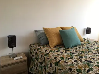 a bedroom with a bed with pillows and two speakers at City Center Private Parking AC in Porto
