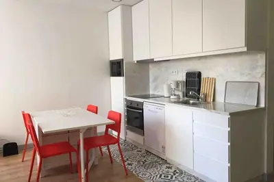 a kitchen with a table and red chairs and a counter at City Center Private Parking AC in Porto