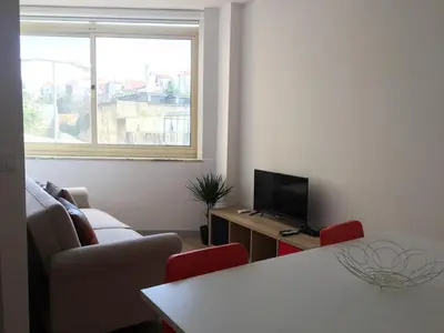 a living room with a couch and a table and a television at City Center Private Parking AC in Porto