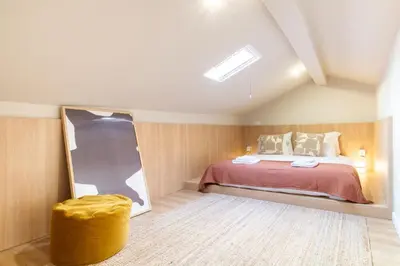 a bedroom with a large bed in a attic at Bright 3BR Flat near Douro with AC by LovelyStay in Vila Nova de Gaia