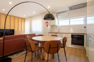 a kitchen and living room with a table and a couch at Bright 3BR Flat near Douro with AC by LovelyStay in Vila Nova de Gaia