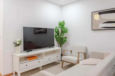 a living room with a tv on a white entertainment center at Bright & Cozy Apartment by HostWise in Vila Nova de Gaia