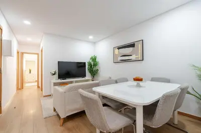a living room with a white table and a tv at Bright & Cozy Apartment by HostWise in Vila Nova de Gaia