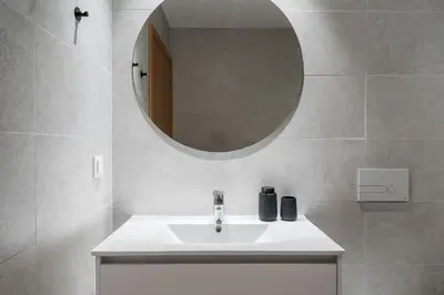 a white living room with a tv on a white cabinet at New Luxurious, Spacious Studio With Parking in Vila Nova de Gaia