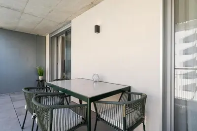 a green table and chairs in a room at New Luxurious, Spacious Studio With Parking in Vila Nova de Gaia