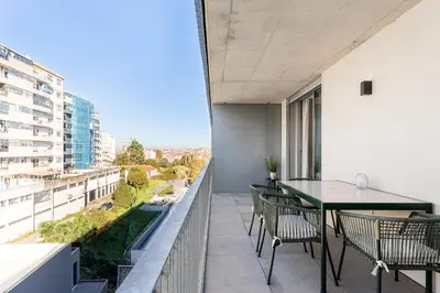 a balcony with a table and chairs on a building at New Luxurious, Spacious Studio With Parking in Vila Nova de Gaia