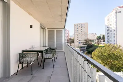 a balcony with a table and chairs on a building at New Luxurious, Spacious Studio With Parking in Vila Nova de Gaia