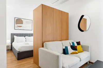 a bedroom with a bed and a couch and a chair at New Luxurious, Spacious Studio With Parking in Vila Nova de Gaia
