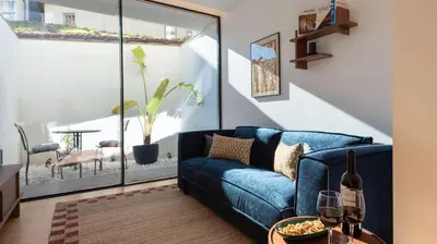 a living room with a blue couch and wine glasses at Ando Living - São Miguel House in Porto