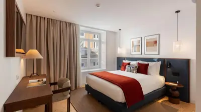 a hotel room with a bed and a desk at Ando Living - São Miguel House in Porto