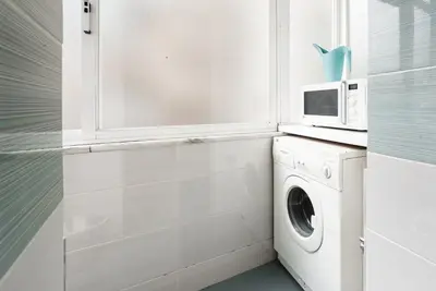a kitchen with a washing machine and a microwave at GuestReady Essential - Heartbeats in Porto