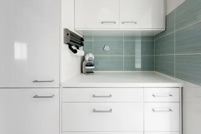 a kitchen with white cabinets and a camera on the wall at GuestReady Essential - Heartbeats in Porto