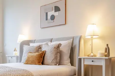 a bedroom with a bed with pillows and a lamp at Modern & Spacious Flat with Garage by HostWise in Vila Nova de Gaia